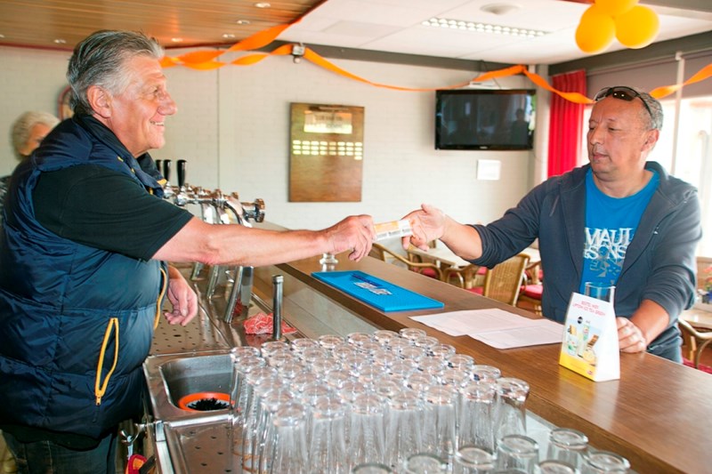 Vrijwilliger helpt tennisser aan de bar