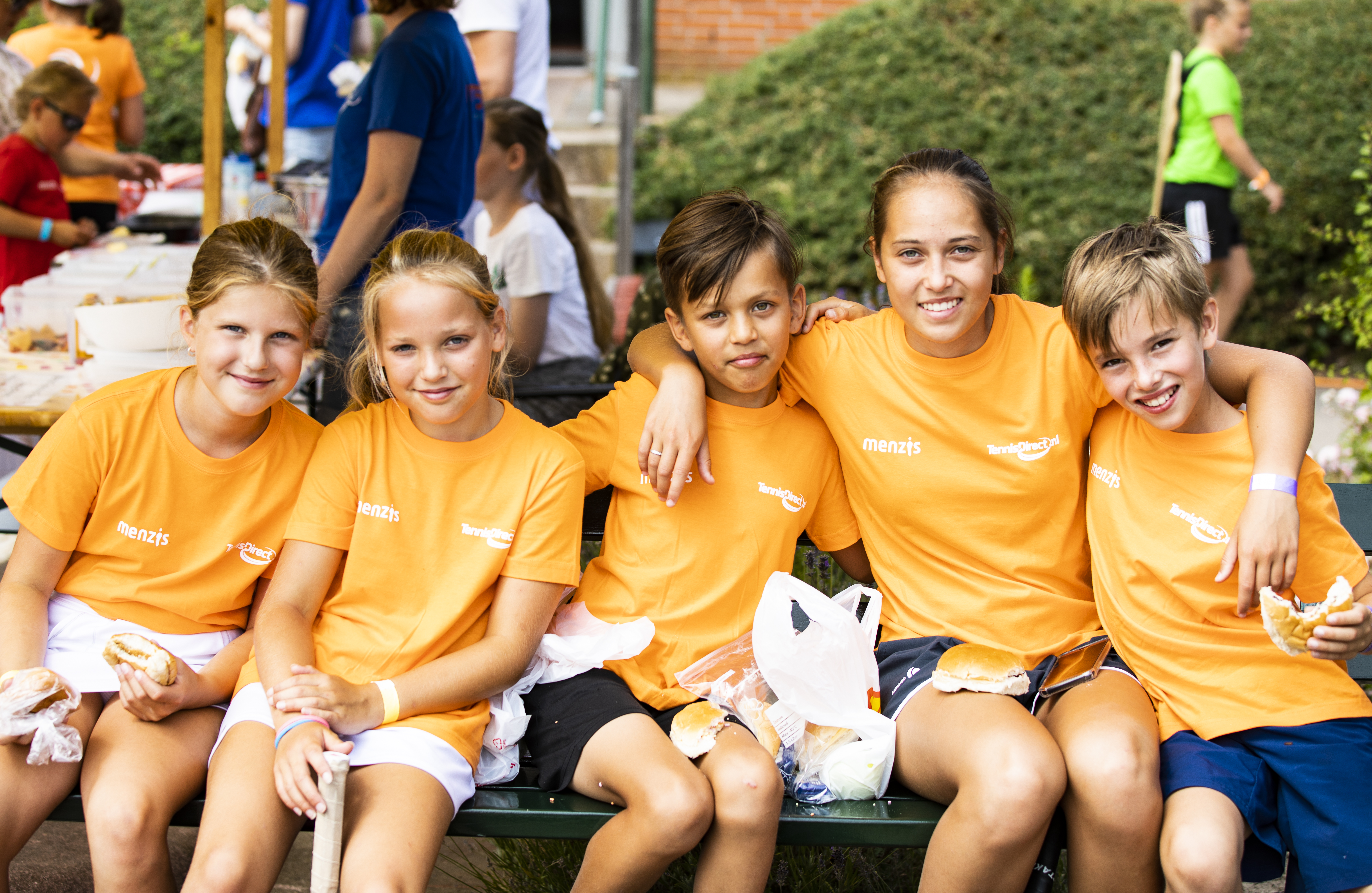 tenniskids oranje arm in arm groepsfoto